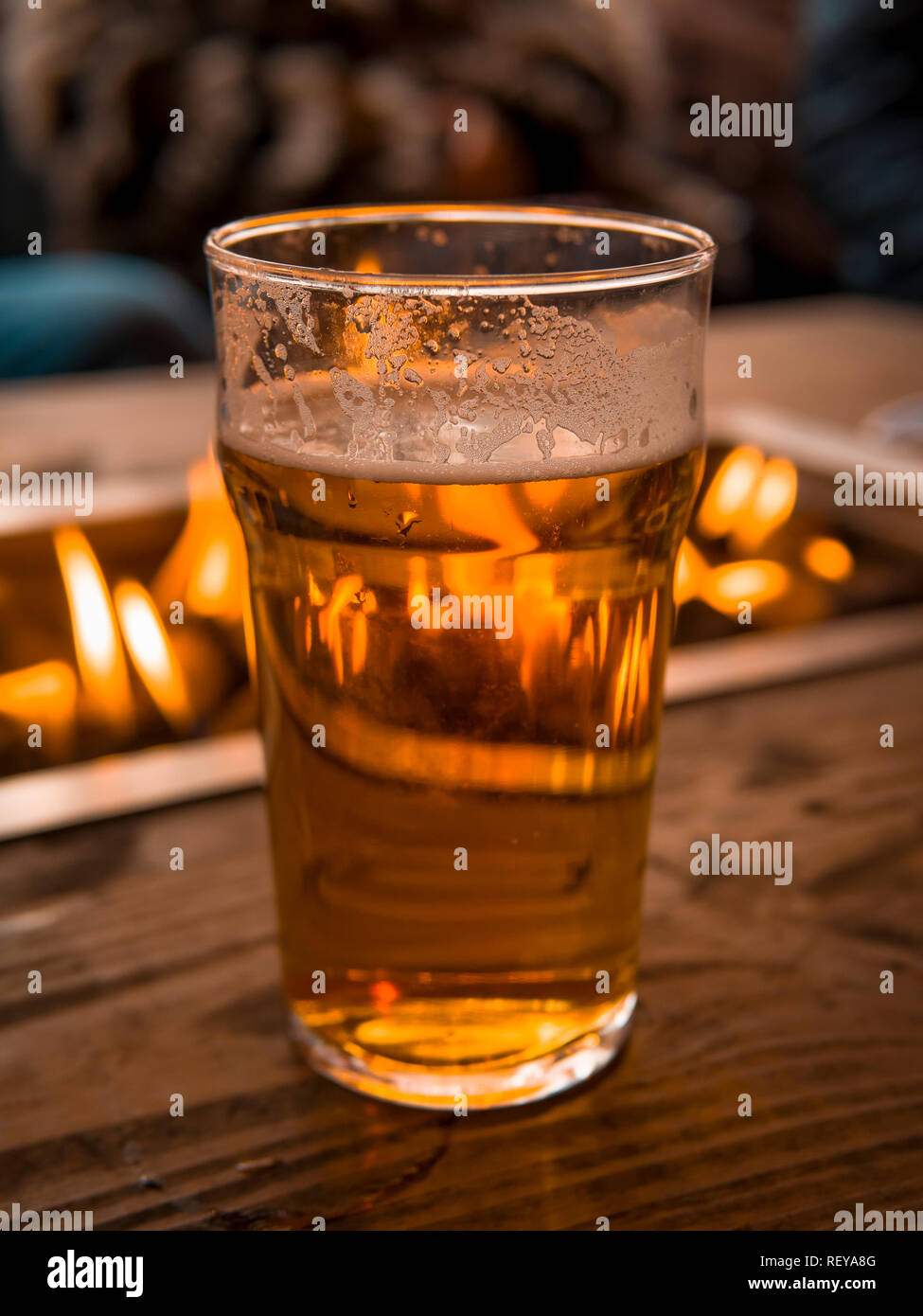 Pint Bier außerhalb neben einer Feuerstelle Stockfoto