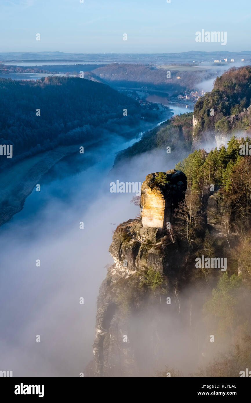 Landschaft im Nationalpark Sächsische Schweiz mit Felsformationen, Gipfel Wartturm und Bäume, Nebel in der Elbe Valley bei Sonnenaufgang Stockfoto
