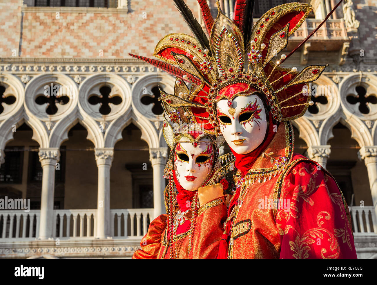 Karneval in Venedig. Zwei wunderschöne venezianische Karnevalsmasken mit dem berühmten Doge Palast im Hintergrund Stockfoto