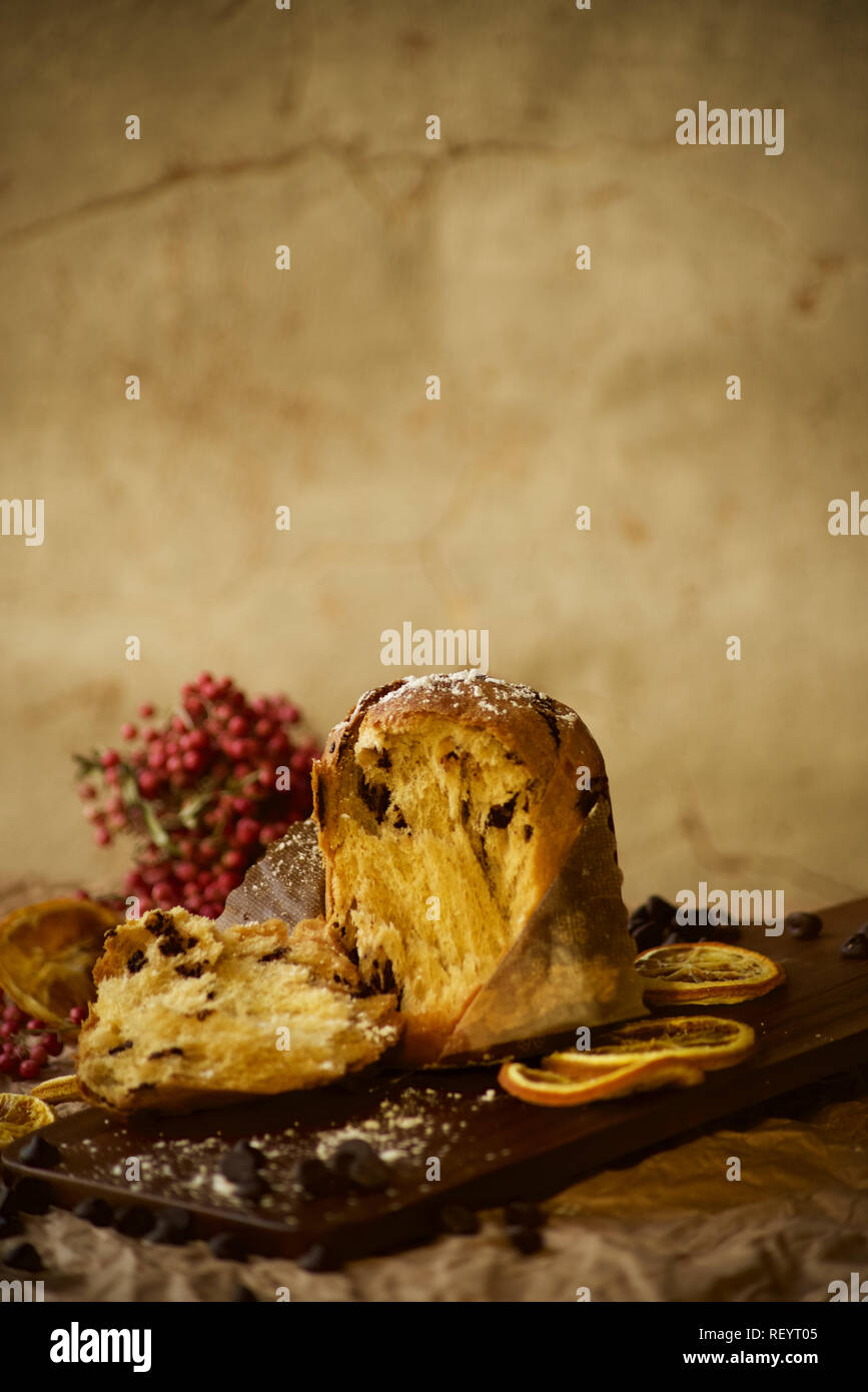 Italienischer Panettone auf Holzbrett mit warmem Hintergrund. Saisonale Kuchen Silvester Feier Essen. Stockfoto