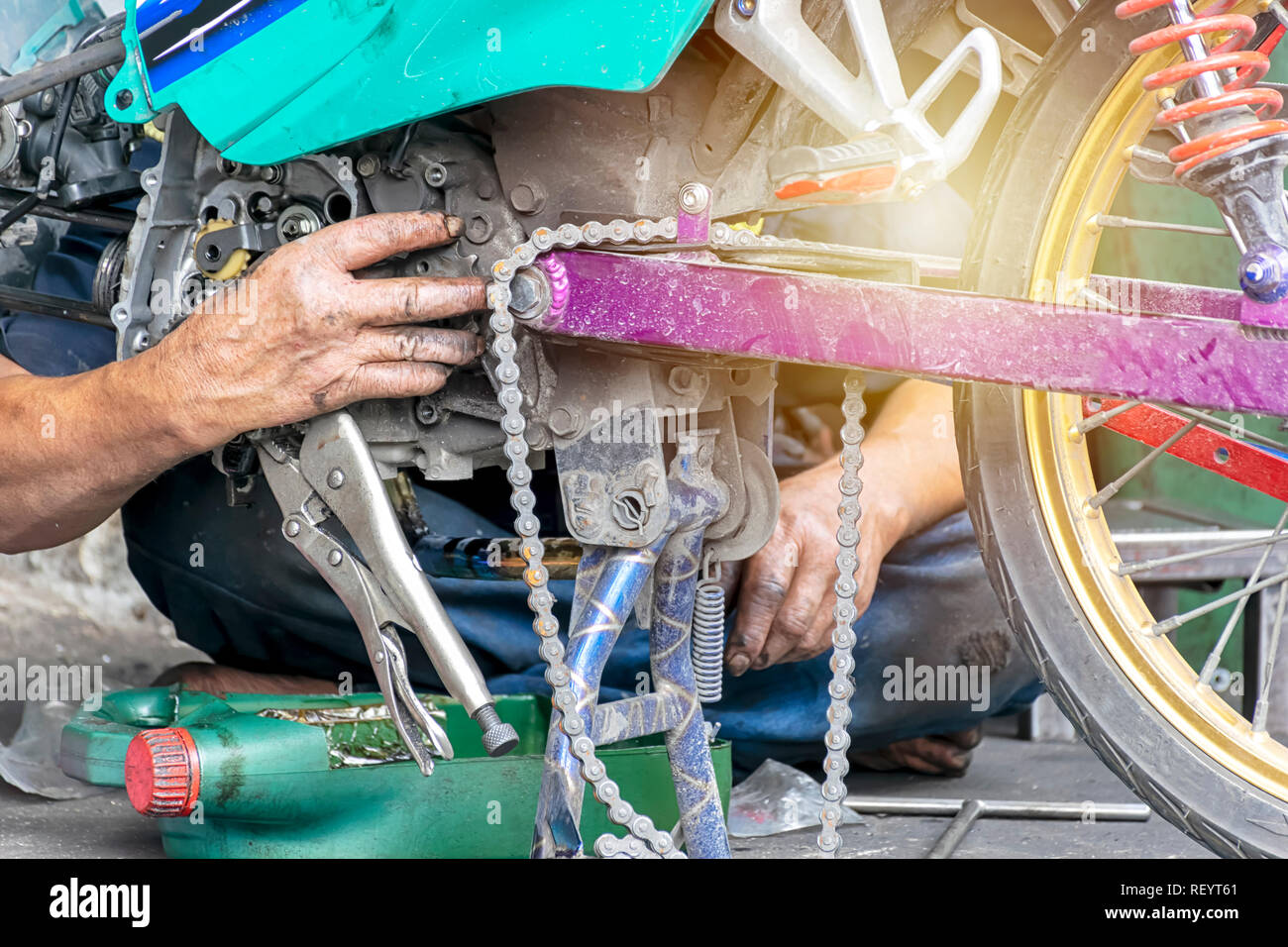 Motorrad Motor Reparatur Arbeiter sind hart zu arbeiten. Komplizierte Probleme lösen, Maschinenbau. Die Hand, die das Öl riecht. Stockfoto