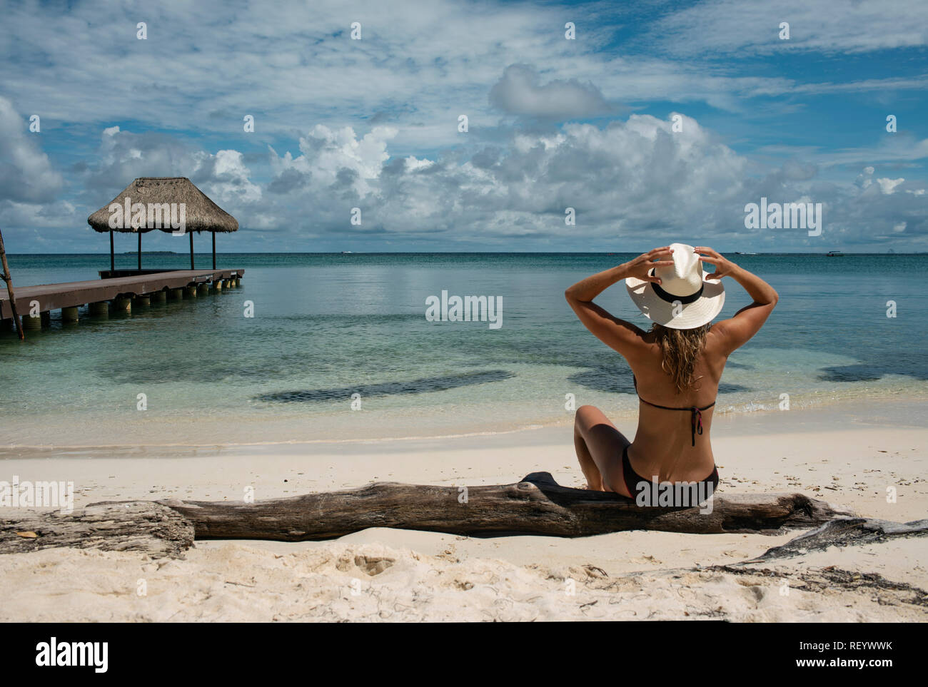 Ansicht der Rückseite Frau sitzt am tropischen Strand von Isla Grande, Rosario Inseln. Lifestyle / Travel Concept. Cartagena de Indias, Kolumbien. Okt 2018 Stockfoto