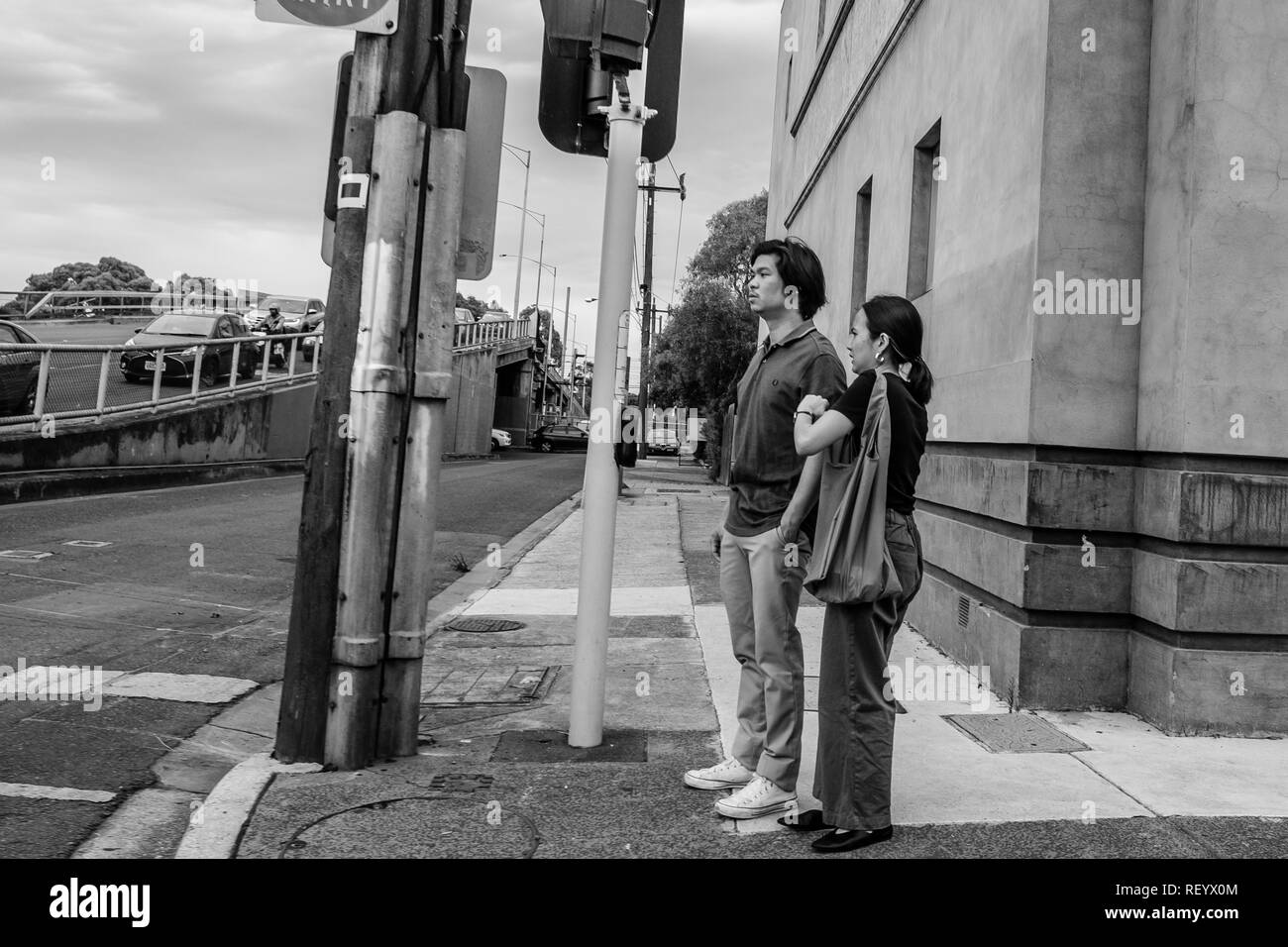 Ein Mann und eine Frau stand an einer Ampel in den Straßen von Melbourne, Australien Stockfoto