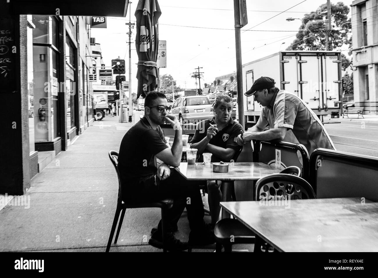 3 Männer haben Kaffee in den Straßen von Melbourne, Australien Stockfoto