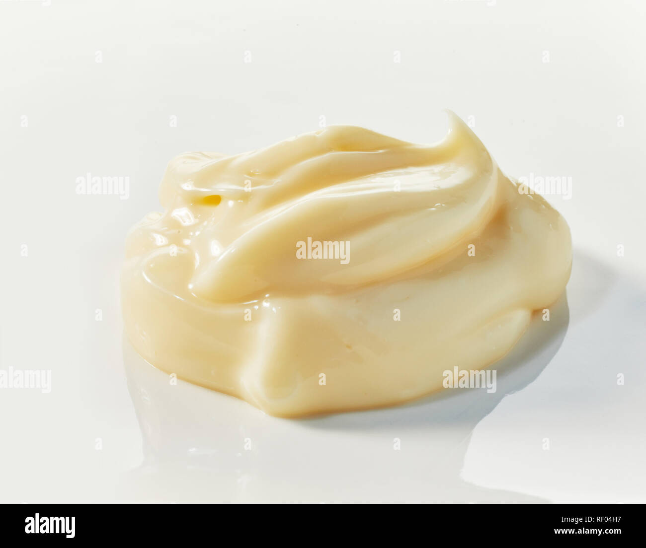 Low profile Twist gourmet Mayonnaise mit Reflexion auf Weiß in Nahaufnahme Seitenansicht für foodstyling Konzepte Stockfoto