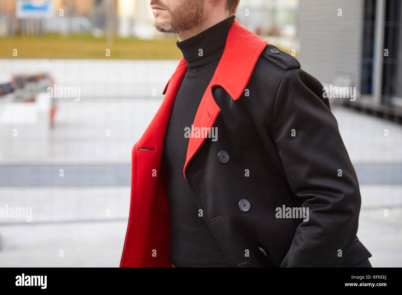 Mailand, Italien - Januar 12, 2019: Mann mit schwarzen Rollkragenpullover und schwarzen und roten Mantel vor Neil Barrett fashion show, Mailand Fashion Week street style Stockfoto