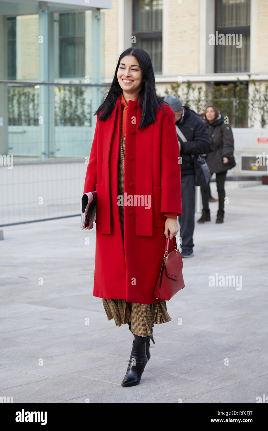 Mailand, Italien - Januar 12, 2019: Frau mit roten Mantel und Tasche, bevor Neil Barrett fashion show, Mailand Fashion Week street style Stockfoto