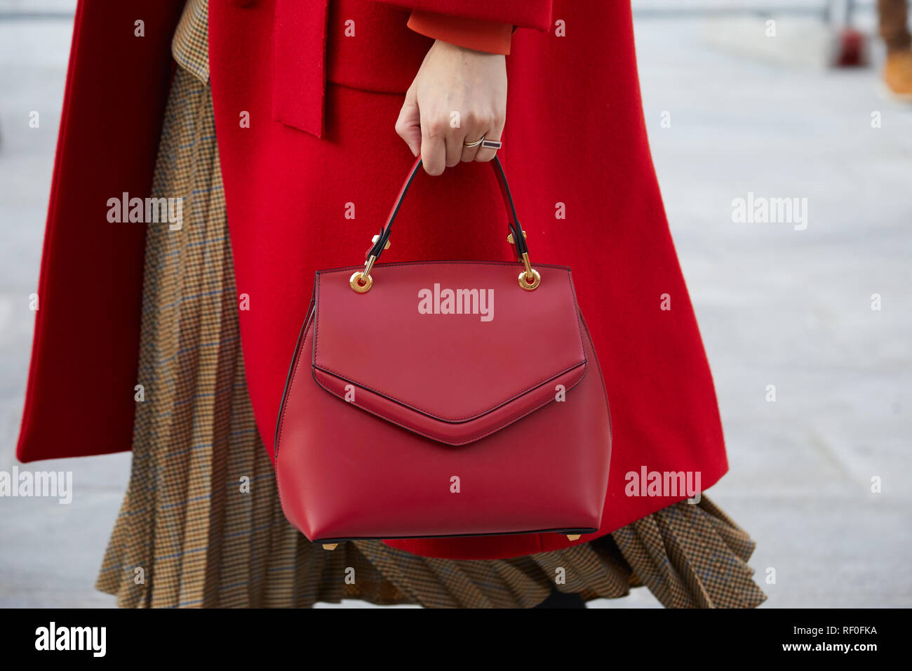 Mailand, Italien - Januar 12, 2019: Frau mit roten Mantel und roten Gnade Han Leder Tasche, bevor Neil Barrett fashion show, Mailand Fashion Week street style Stockfoto