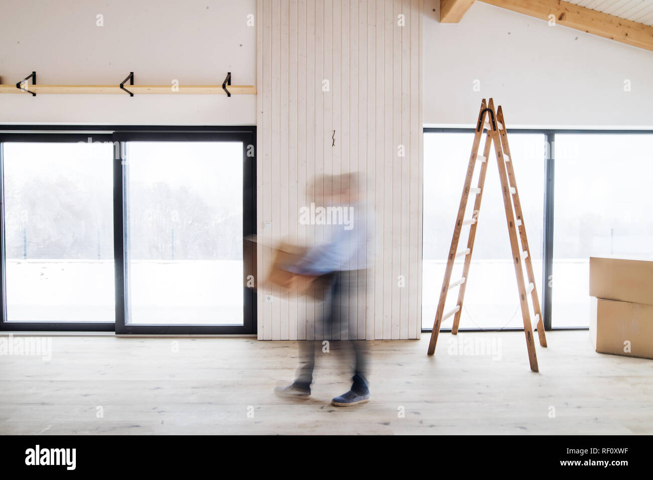 Eine nicht erkennbare Mann mit Kartons bei der Einrichtung neues Haus. Vorsätzliche Bewegungsunschärfe. Stockfoto