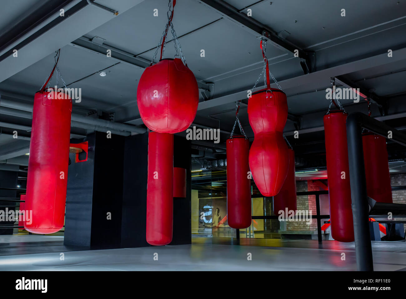 Red Boxsäcke mit Fitnessraum Hintergrund. Birnen für Boxen Stockfoto