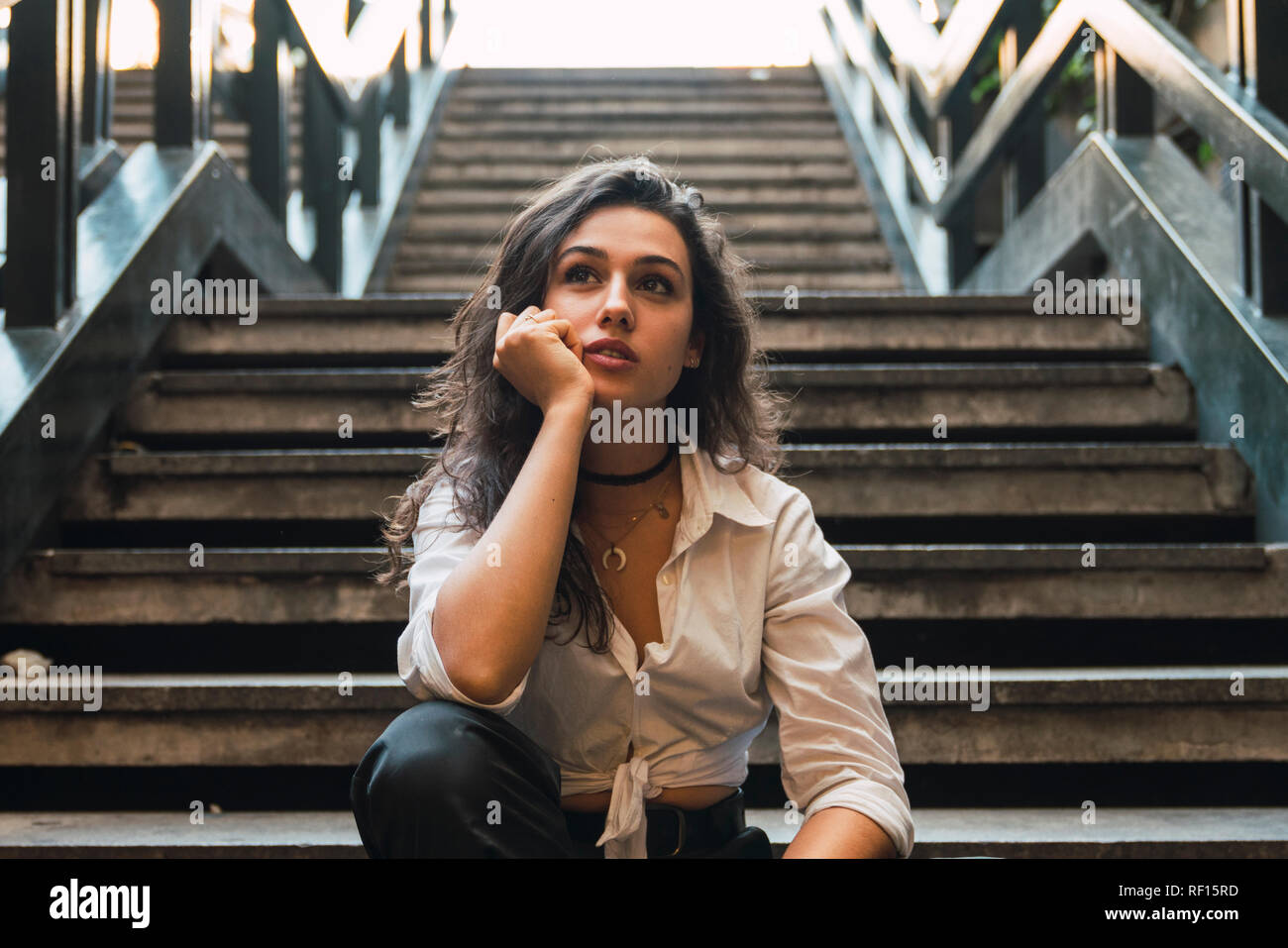 Portrait von junge Frau sitzt auf der Treppe Stockfoto