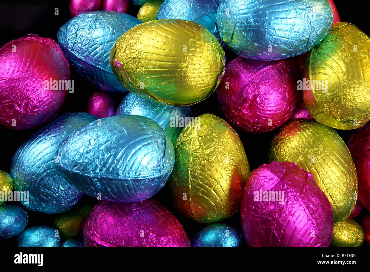 Haufen von Folie eingewickelt Schokoladeneier in rosa, blau & lindgrün. Stockfoto