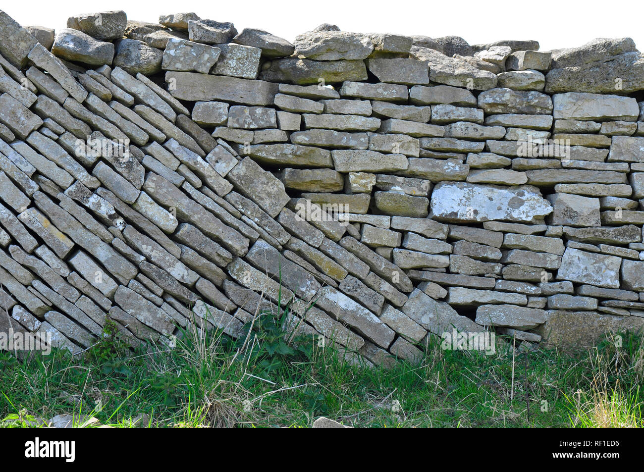 Trockenmauer mit einer Mischung aus Niveau und abfallende Kurse auf der Isle of Purbeck, Dorset. Grobe Kalkstein Mauer trennt die Felder an der Küste. Stockfoto