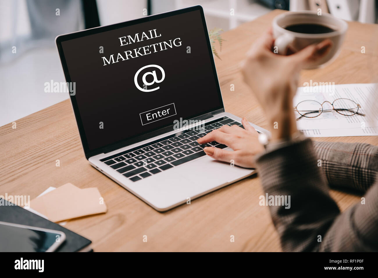 7/8-Ansicht von geschäftsfrau mit Kaffee Tasse schreiben auf Laptop mit E-Mail Marketing Stockfoto