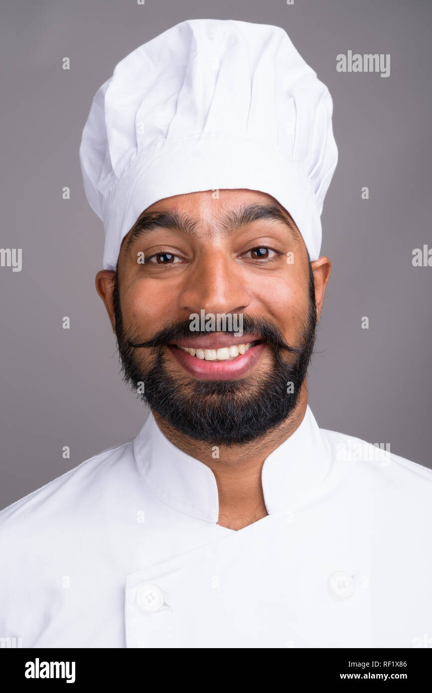 Gesicht der jungen schönen Indischen Mann Chef lächelt Stockfoto