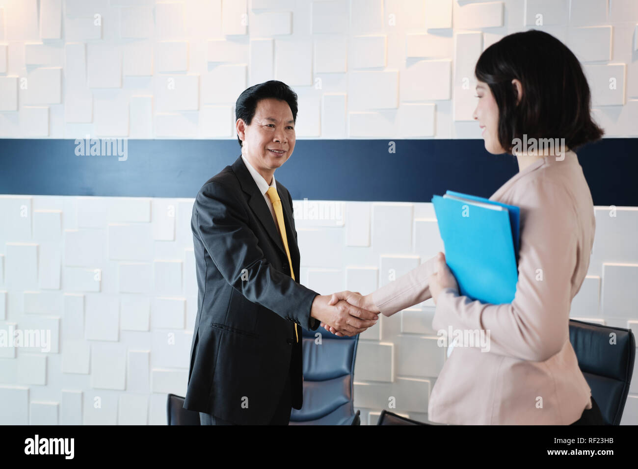 Handshake zwischen Glücklichen asiatischen Manager und Hispanic Geschäftsfrau im Büro Stockfoto
