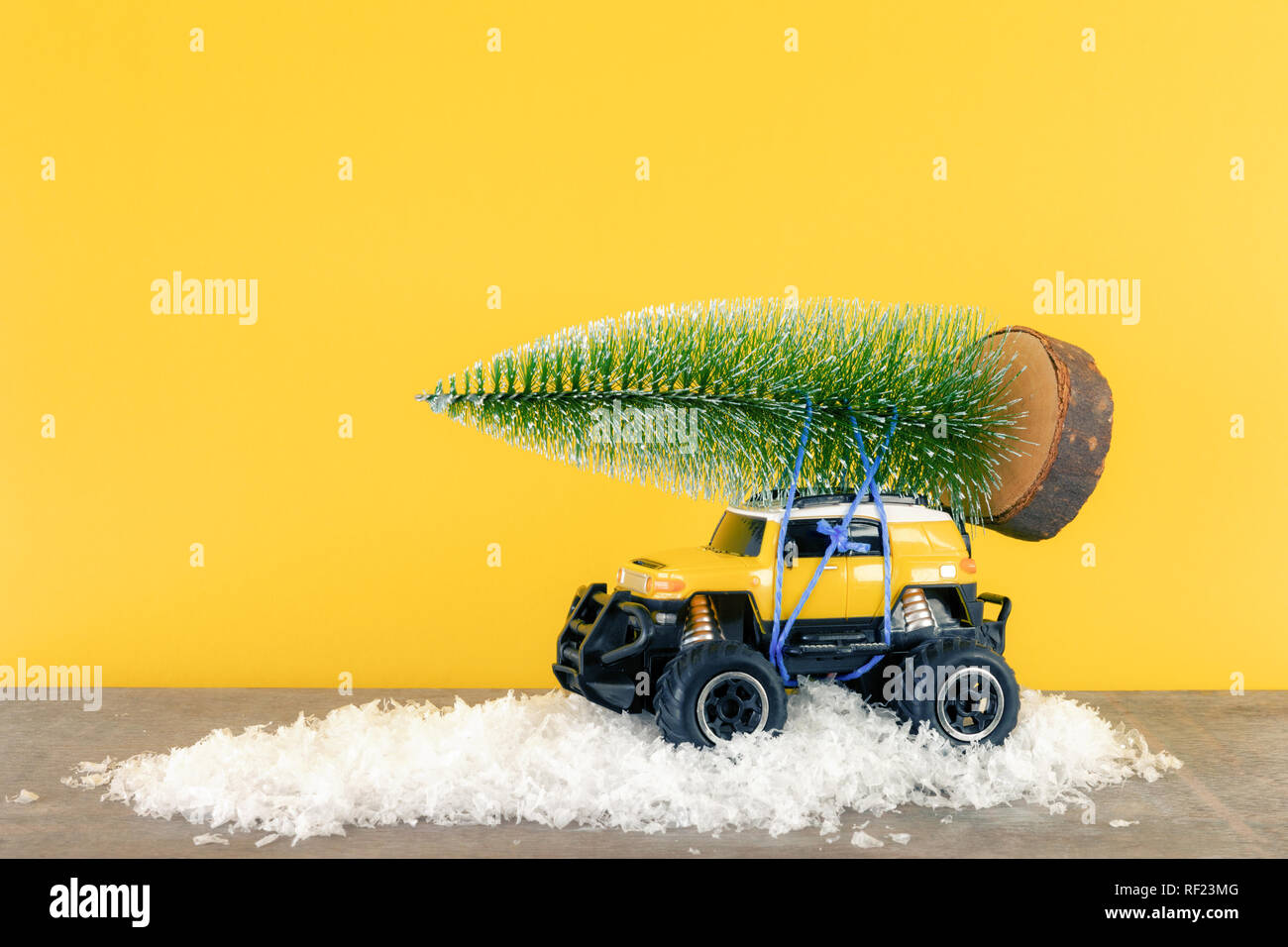 Ein Bild von einem gelben Auto SUV Monster truck Spielzeug mit Tannenbaum Stockfoto