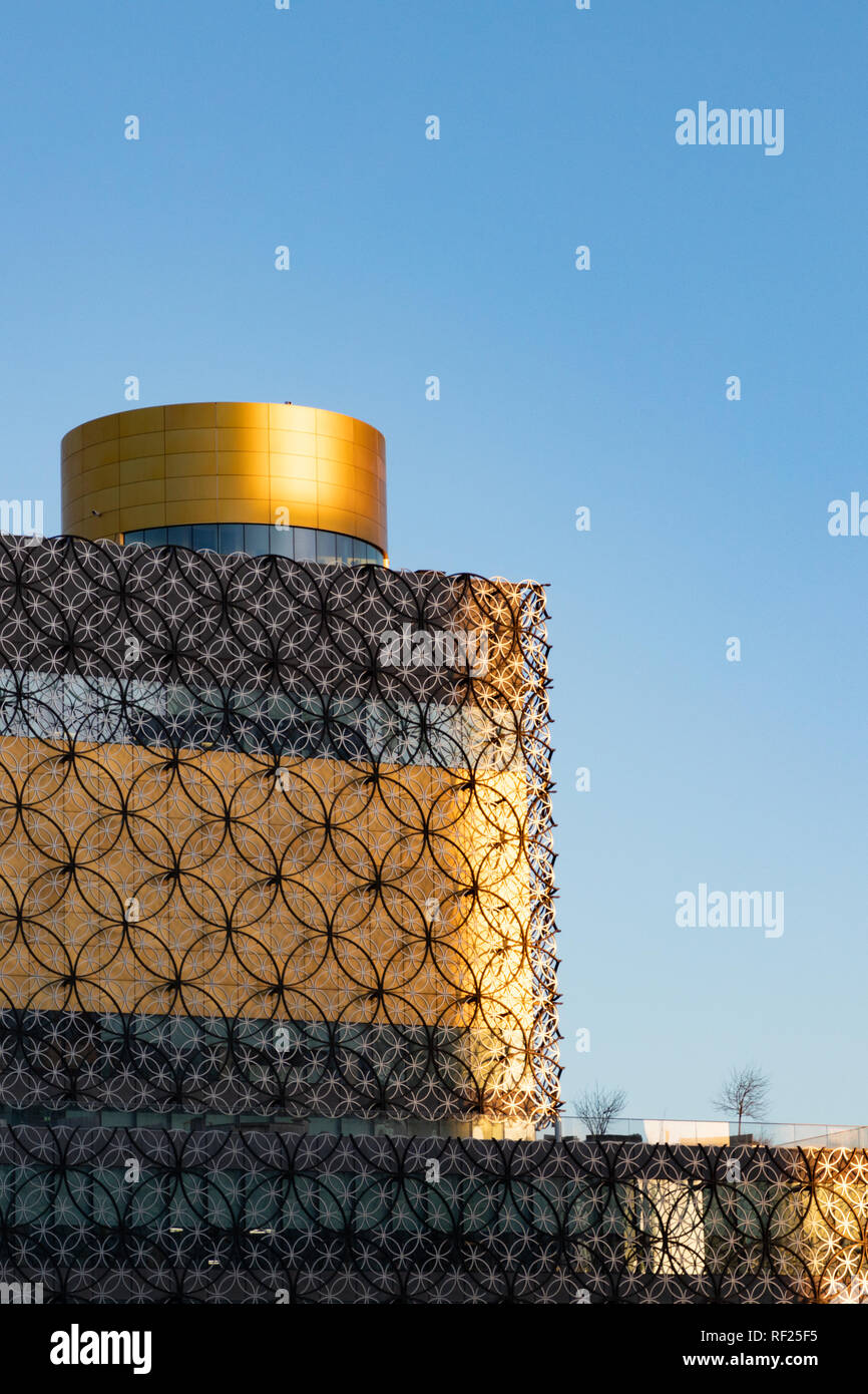 Birmingham, Großbritannien - 22 Januar 2019: Zentrale Bibliothek mit dem morgendlichen Sonnenlicht auf den Kanten, Gelb und Gold Farben zeichnen sich gegen den blauen Himmel. Stockfoto