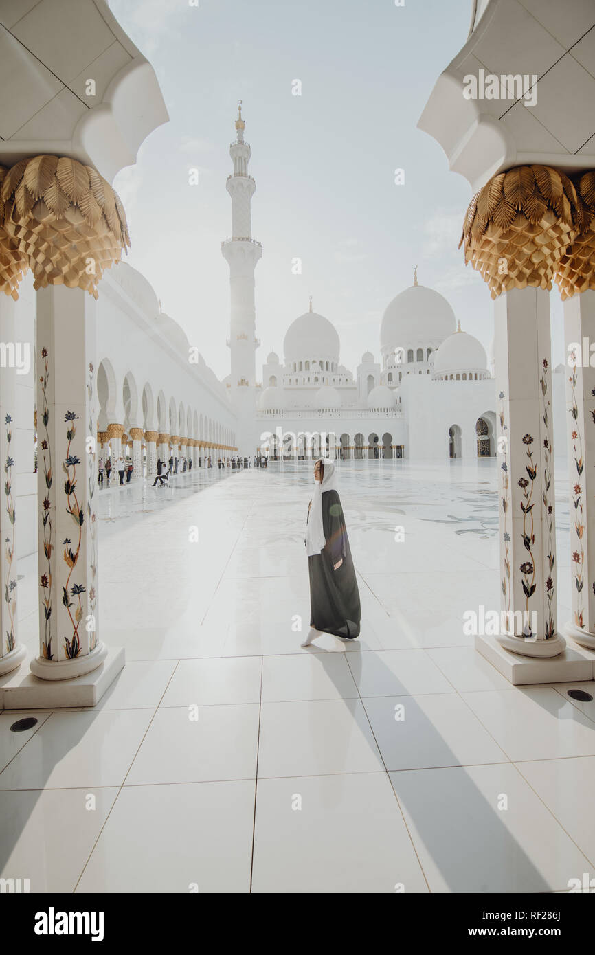 Reisen mit Unated Arabische Emirate. Frau in traditionellen Abaya stehend in der Sheikh Zayed Grand Moschee, berühmten Abu Dhabi Besichtigungen. Stockfoto