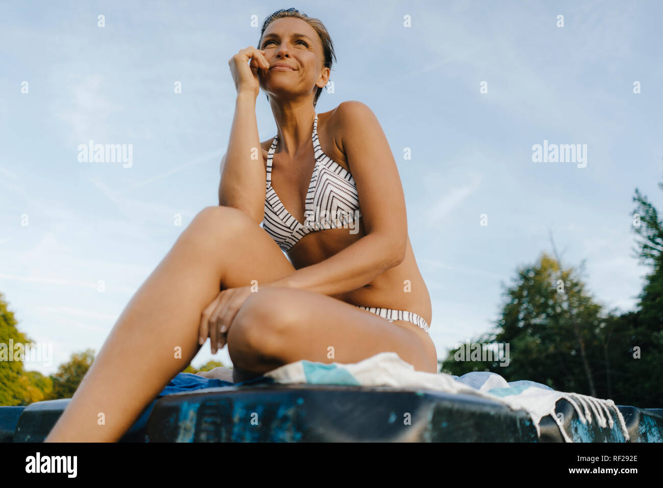 Frau im Bikini sitzt auf einem Schwimmer Stockfoto
