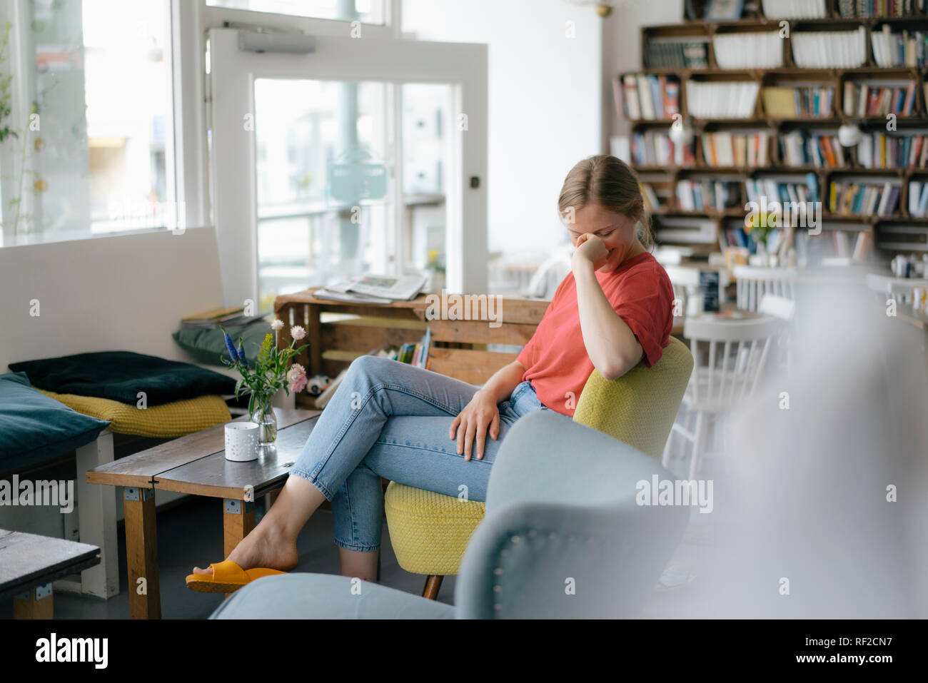 Glückliche junge Frau, die in einem Cafe sitzen Stockfoto