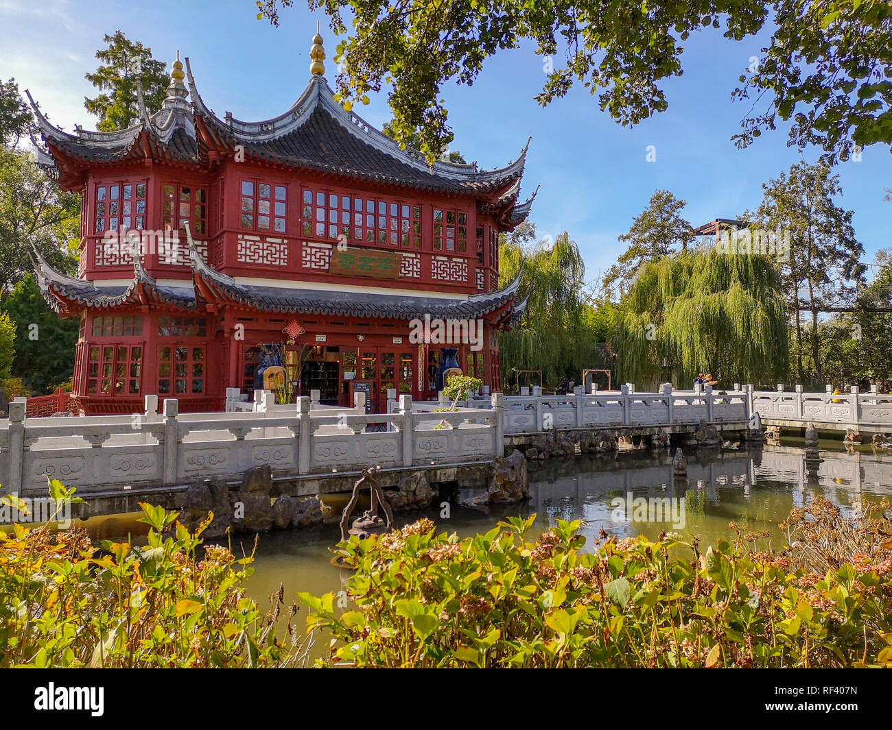 September 2018 - Brugelette, Belgien: der teepavillon im traditionellen roten Farbe mit blauer Dachbalken in der Chinesische Garten im Zoo Pairi Daiza Stockfoto