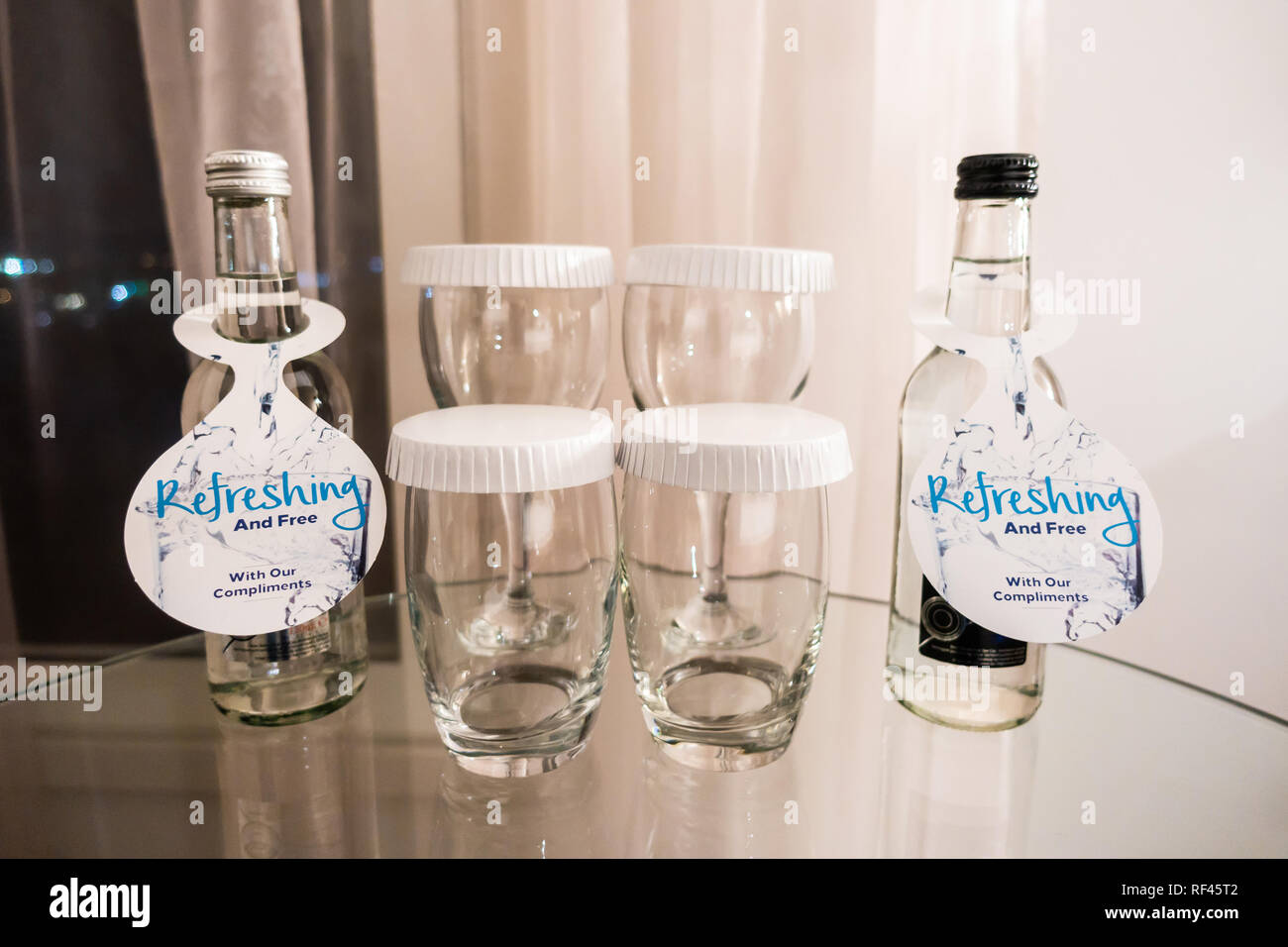 Kostenlose Flaschen Wasser mit Brille in einem Hotelzimmer. Stockfoto