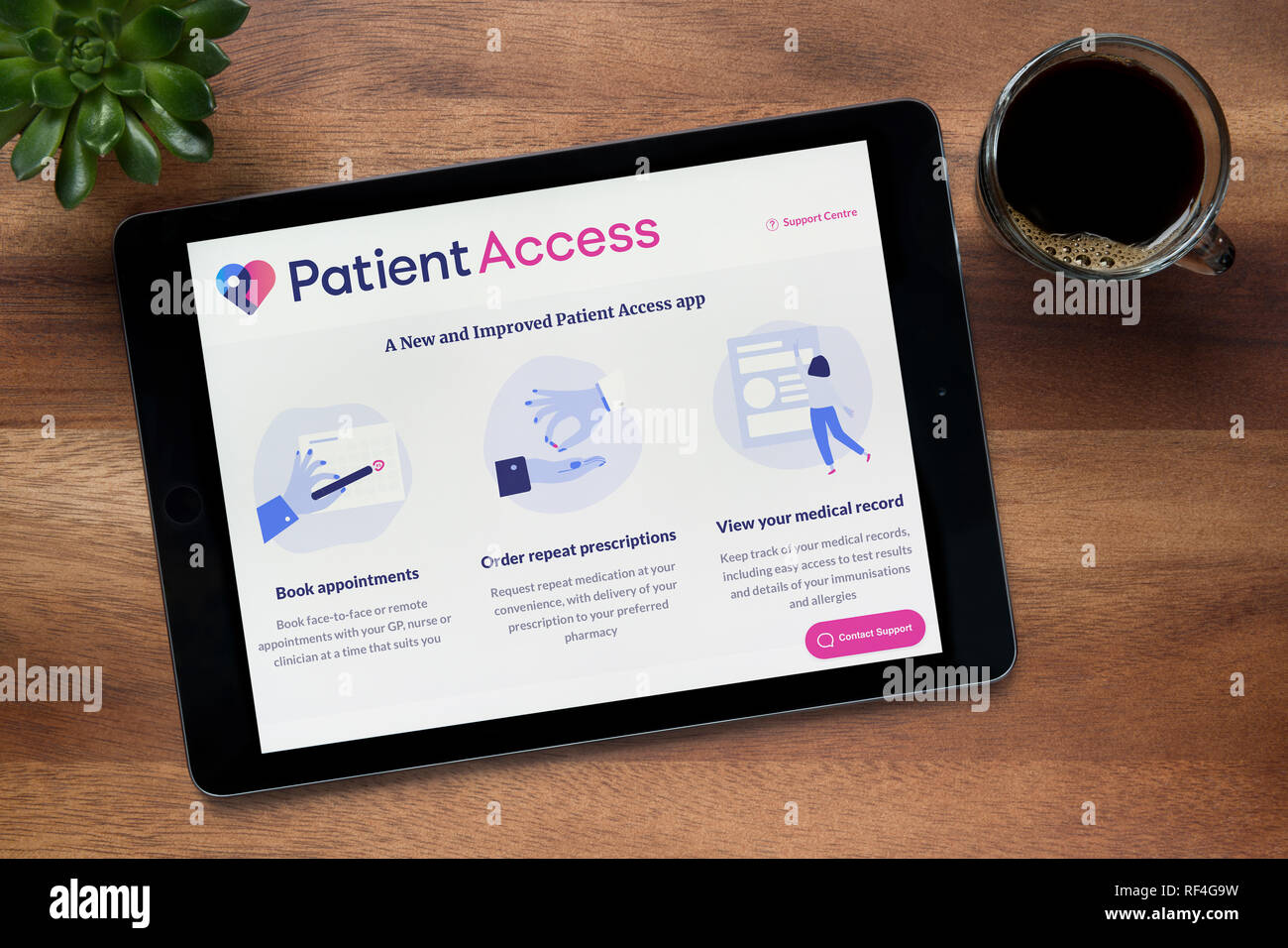Die Website von Patient Access ist auf einem iPad Tablet gesehen, auf einer hölzernen Tisch zusammen mit einem Espresso und einem Haus Anlage (nur redaktionelle Nutzung). Stockfoto