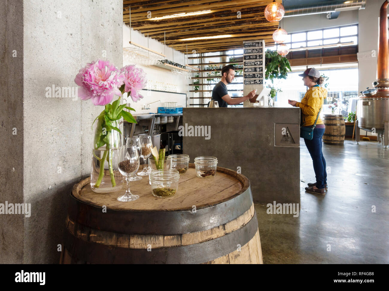 Eine Frau Kunde patron Besucher genießt eine Weinprobe an der Bar. Amalga lokale Distillery Innenraum, Juneau, Alaska Stockfoto