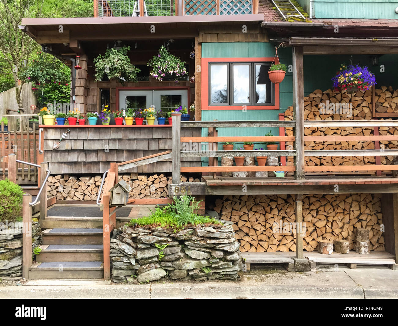 Stapel von Brennholz gespeichert außerhalb eines typischen rustikalen Haus in Juneau, Alaska. Holz Öfen sind noch allgemein für zu Hause die Heizung verwendet. Stockfoto