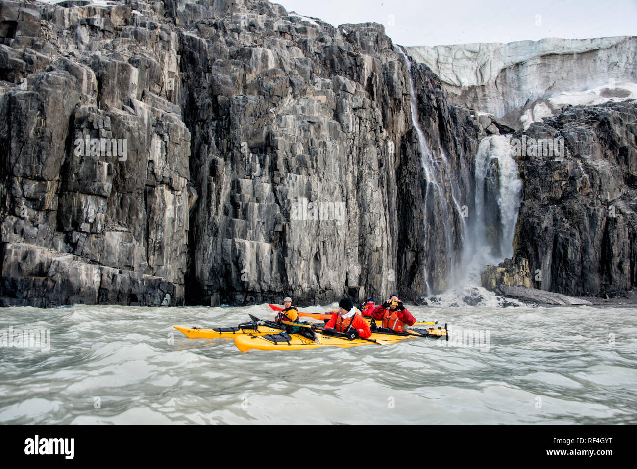 SVALBARD, Norwegen - Kajaktouristen erkunden das eisige Wasser und die unberührten Landschaften der Arktis rund um Svalbard. Diese einzigartige und abenteuerliche Form des Tourismus bietet ein Erlebnis aus nächster Nähe mit der arktischen Umgebung und zeigt die atemberaubende Schönheit und empfindliche Ökosysteme der Region. Stockfoto