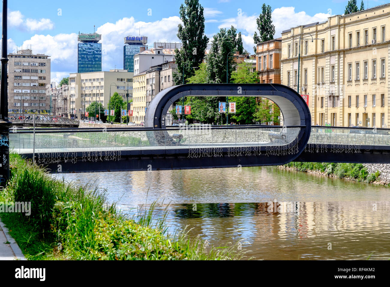 Festina Lente (Lateinisch für 'make Eile langsam') Brücke über den Fluss Miljacka in Sarajewo - die funky loop Design ermahnt Fußgänger, um die Aussicht zu genießen Stockfoto