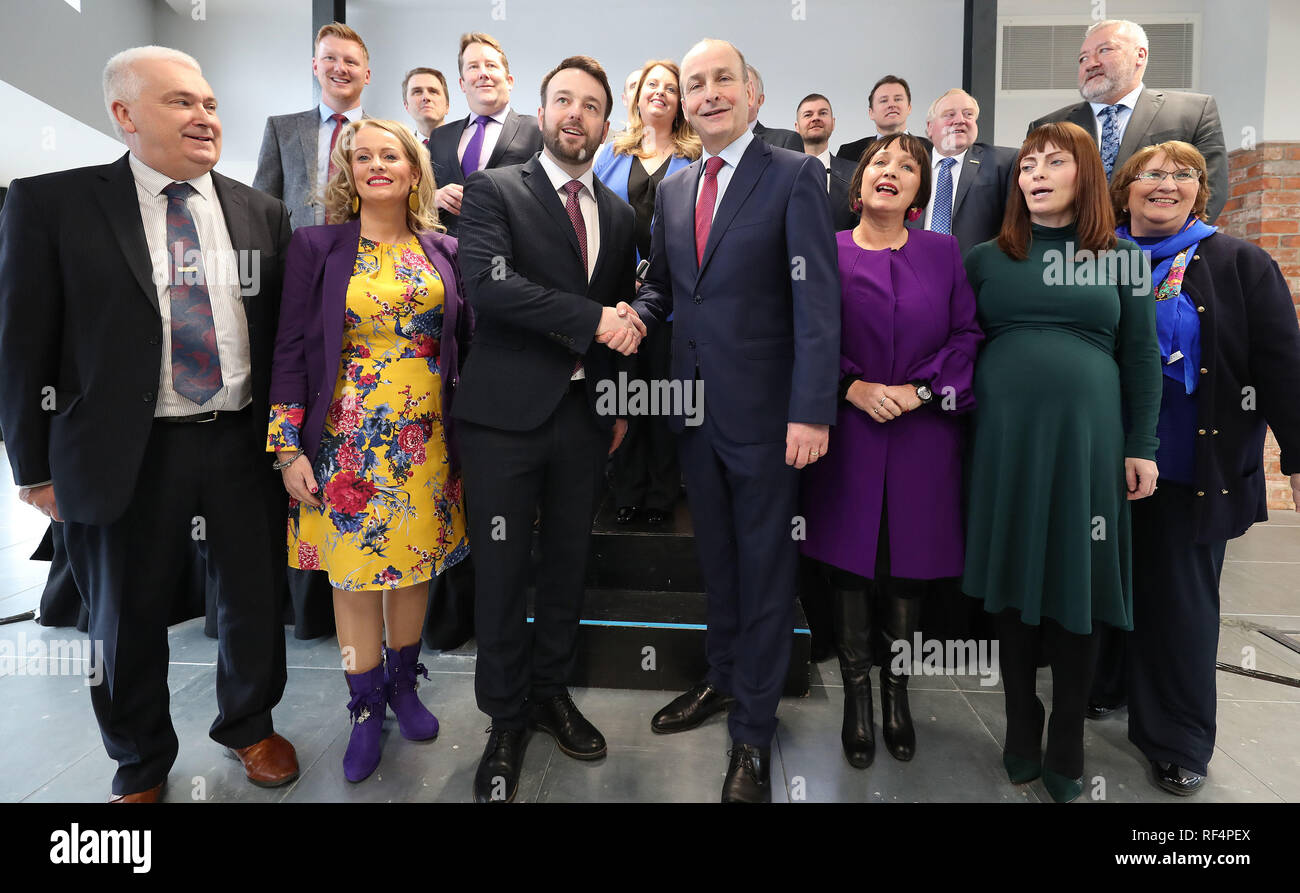 Colum Eastwood der SDLP und Micheal Martin von Fianna Fail posieren für ein Familienfoto mit Party Kollegen in Belfast als ihre politischen Parteien eine neue Partnerschaft bekannt geben. Stockfoto