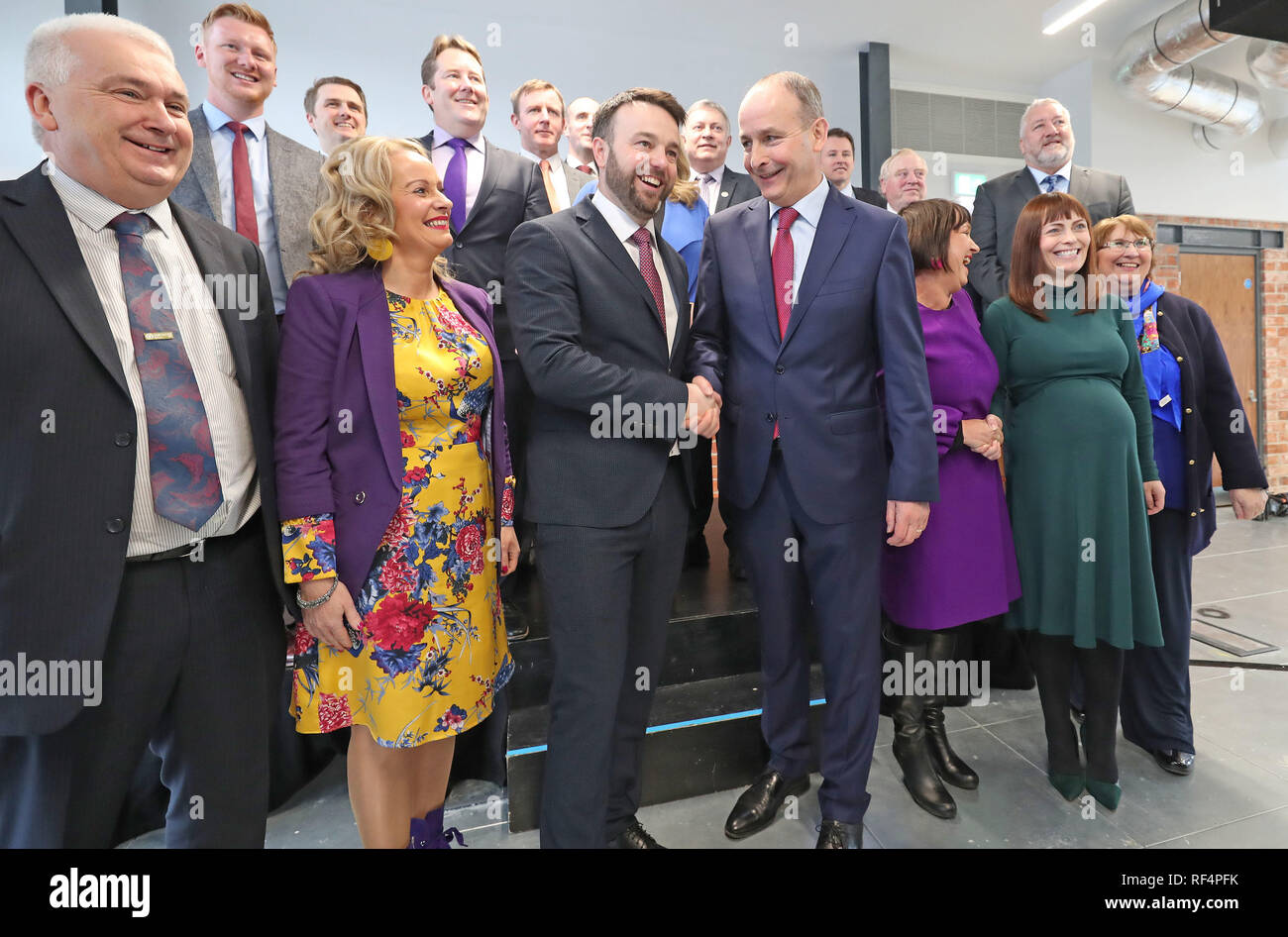 Colum Eastwood der SDLP und Micheal Martin von Fianna Fail posieren für ein Familienfoto mit Party Kollegen in Belfast als ihre politischen Parteien eine neue Partnerschaft bekannt geben. Stockfoto