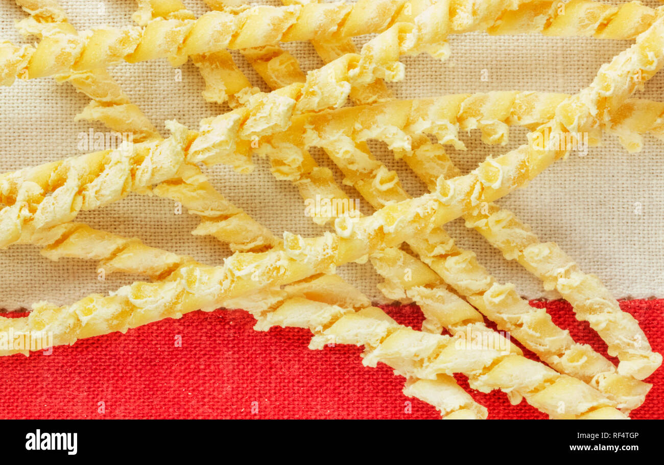 Eine Gruppe italienischer Pasta namens busiate auf eine farbige Tischdecke, verdrehen Stränge der sizilianische Pasta Stockfoto