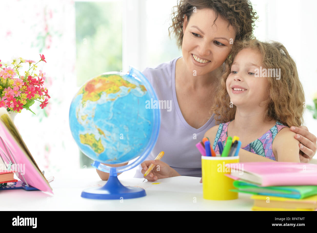 Portrait von cute curly Schulmädchen Hausaufgaben Stockfoto