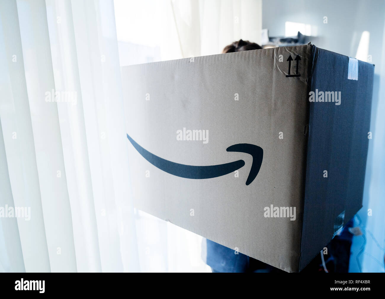 PARIS, Frankreich, 25.Dezember, 2018: blau getönten Bild der Frau mit  großen Amazon Prime Paket Karton am Weihnachtstag mit großen riesige  Geschenk innen Stockfotografie - Alamy