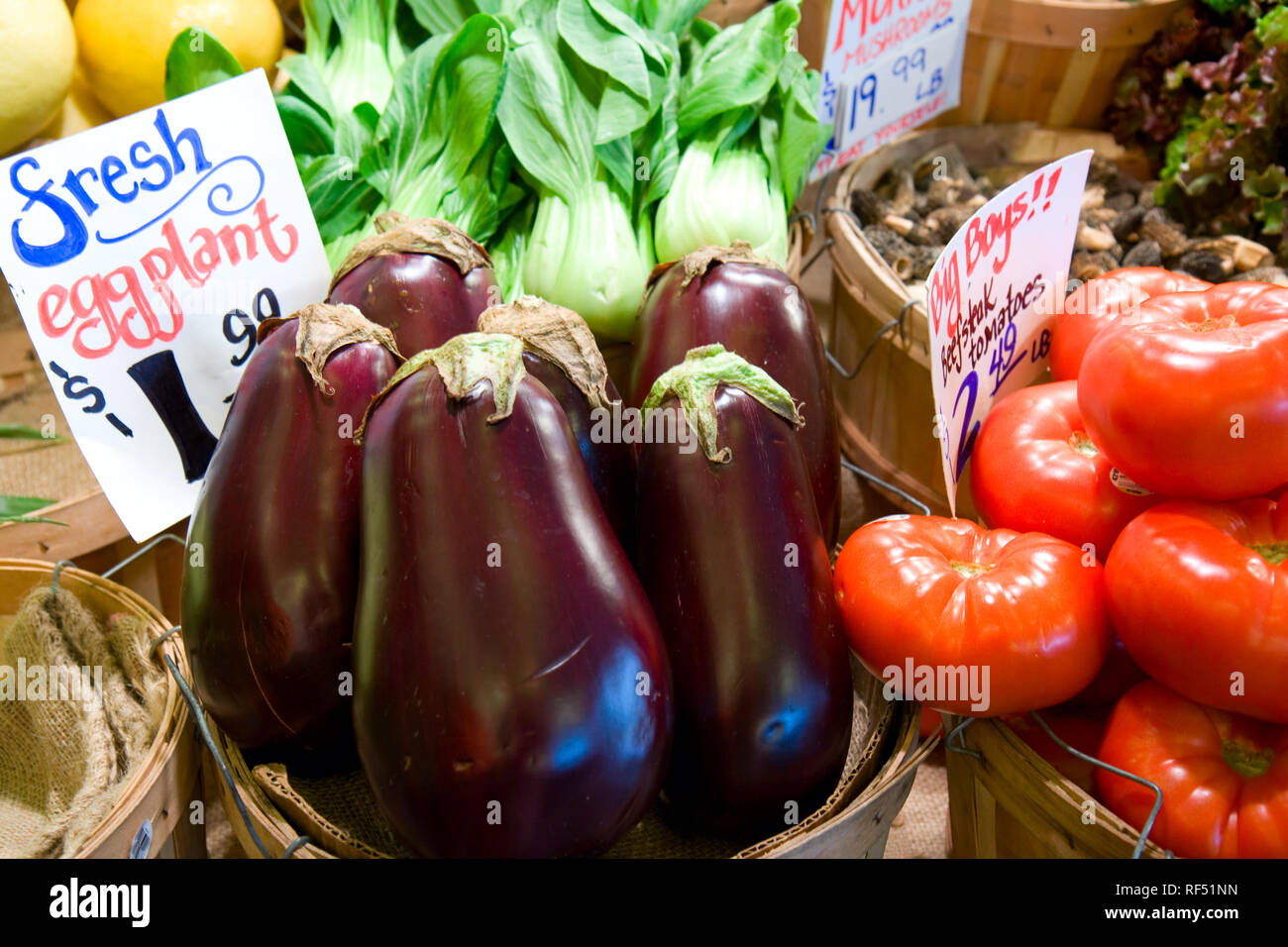 Körbe mit frischen Tomaten und Auberginen sind bis zum Verkauf in Seattle Pikes Place Markt angeboten. Stockfoto