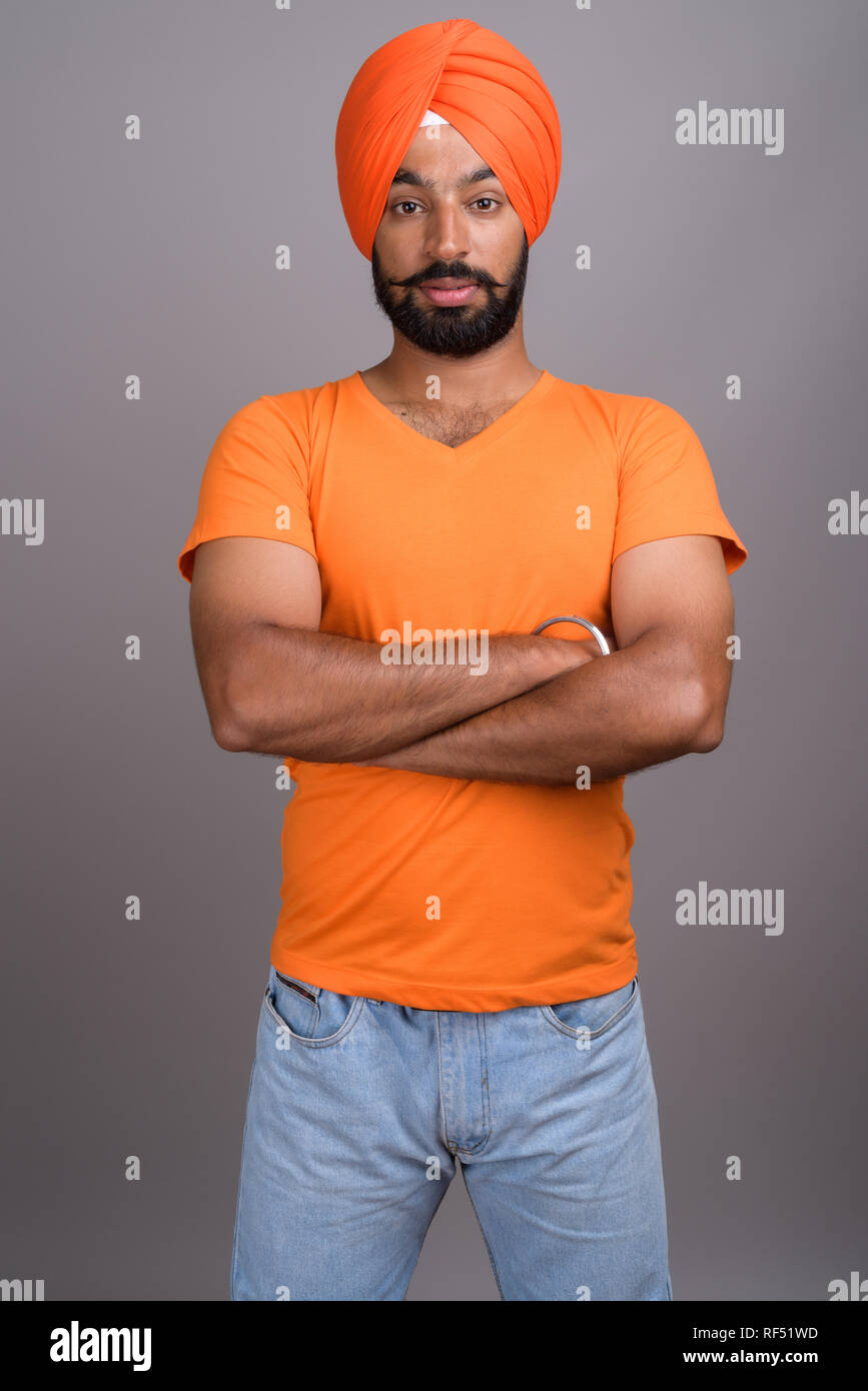 Indische Sikh Mann mit Turban und orangefarbenen T-Shirt Stockfoto