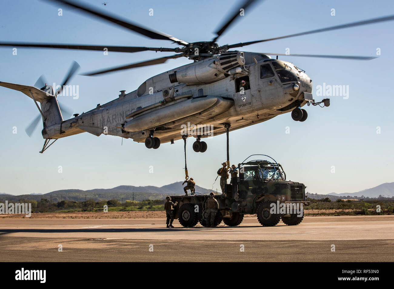 Us-Marines mit 1 Transport Support Battalion, 1 Marine Logistics Group, befestigen Sie ein Medium Tactical Vehicle Ersatz Fahrzeug in den CH-53E Super Stallion bei einem Hubschrauber Support Team (HST) Übung mit Marine schweren Helikopter Squadron 361, 3 Marine Flugzeugflügel bei Marine Corps Air Station Miramar, Kalifornien, Jan. 22, 2019. Das Training wurde ausgeführt, setzen eine HST und CH-53E Super Stallion ein Medium Tactical Vehicle Ersatz-Lkw für den Transport zu heben. (U.S. Marine Corps Foto von Lance Cpl. Betzabeth Y. Galvan) Stockfoto