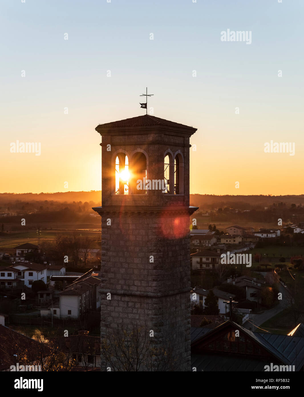 Kirchturm der katholischen Kirche im Dorf auf dem Land bei Sonnenuntergang Stockfoto