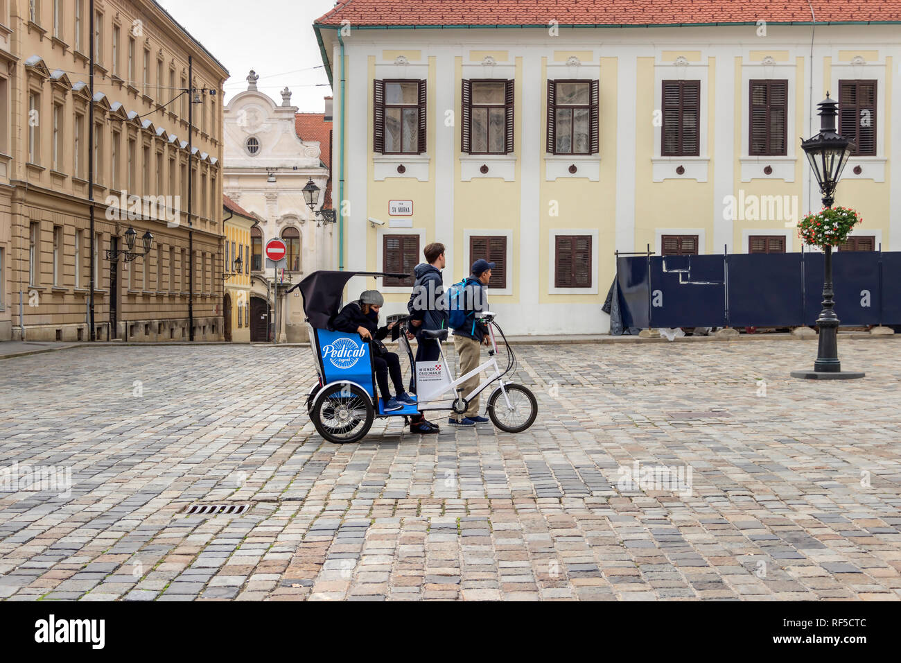 Zagreb, Kroatien, November 2018 - das Pedal und elektrisch angetriebenen Dreirad Rikscha 'Pedicab" mit Touristen, Markusplatz Stockfoto