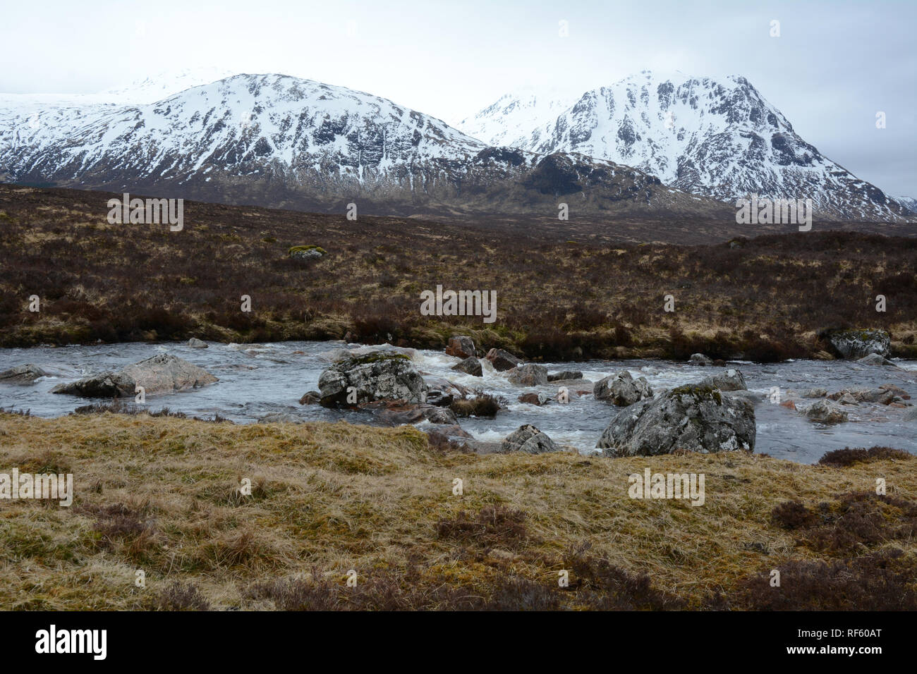 Der Fluss Etive mit den schneebedeckten Gipfeln der Schottischen Highlands im Hintergrund, Glencoe, Schottland, Vereinigtes Königreich. Stockfoto