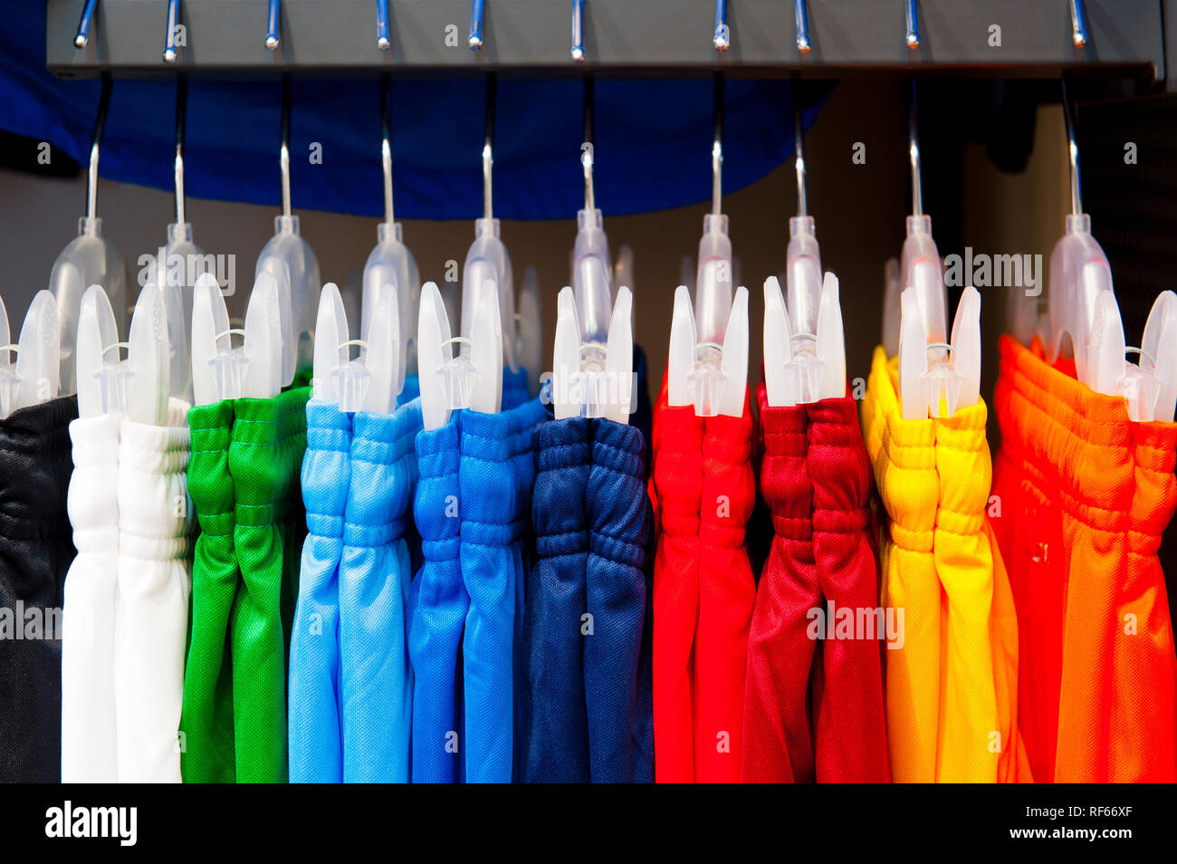 Auswahl an farbenfrohen Fußball oder Fußball Shorts auf Kleiderbügeln im Einzelhandel, Ansicht schließen Stockfoto