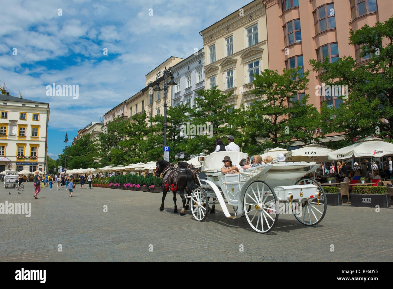Krakau, Polen - 8. Juli 2018. Touristen gehen Sie auf eine Reise rund um die Altstadt von Krakau in einem Pferd angetriebenen wagen, hier in Rynek Glowny, dem historischen Zentrum von Sq Stockfoto