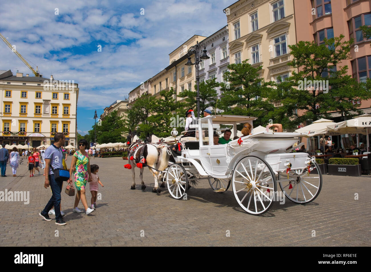 Krakau, Polen - 8. Juli 2018. Touristen gehen Sie auf eine Reise rund um die Altstadt von Krakau in einem Pferd angetriebenen wagen, hier in Rynek Glowny, dem historischen Zentrum von Sq Stockfoto