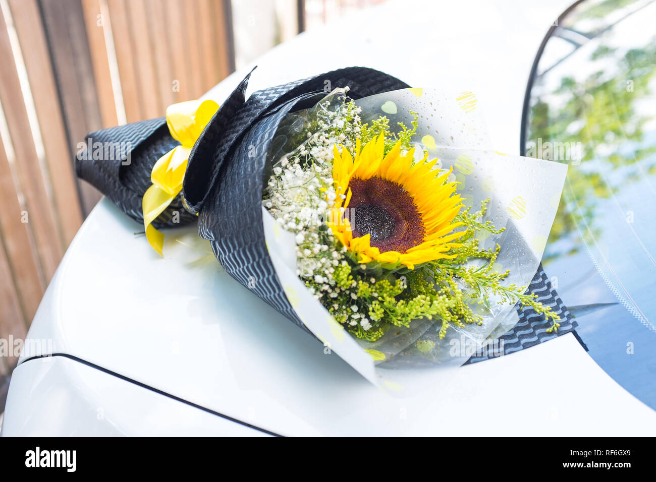 Ein Blumenstrauß aus Sonnenblumen auf ein weißes Auto Stockfotografie -  Alamy
