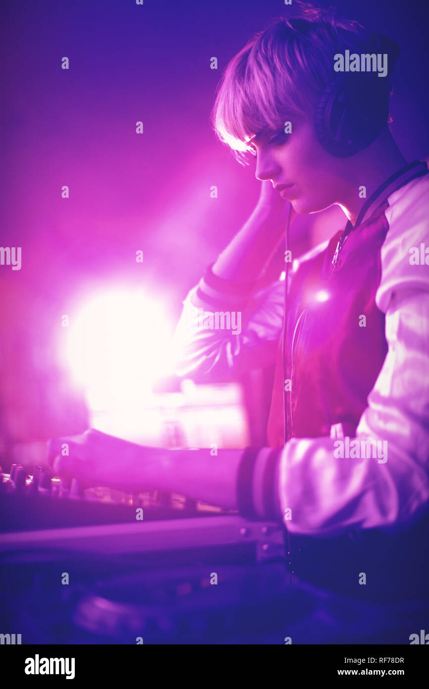 Weibliche DJ Kopfhörer zu hören während der Wiedergabe von Musik Stockfoto