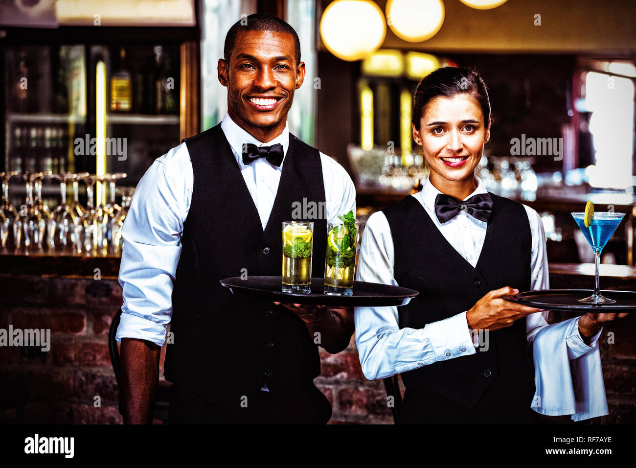 Kellner und Kellnerin hielt ein Tablett mit Glas cocktail Stockfoto