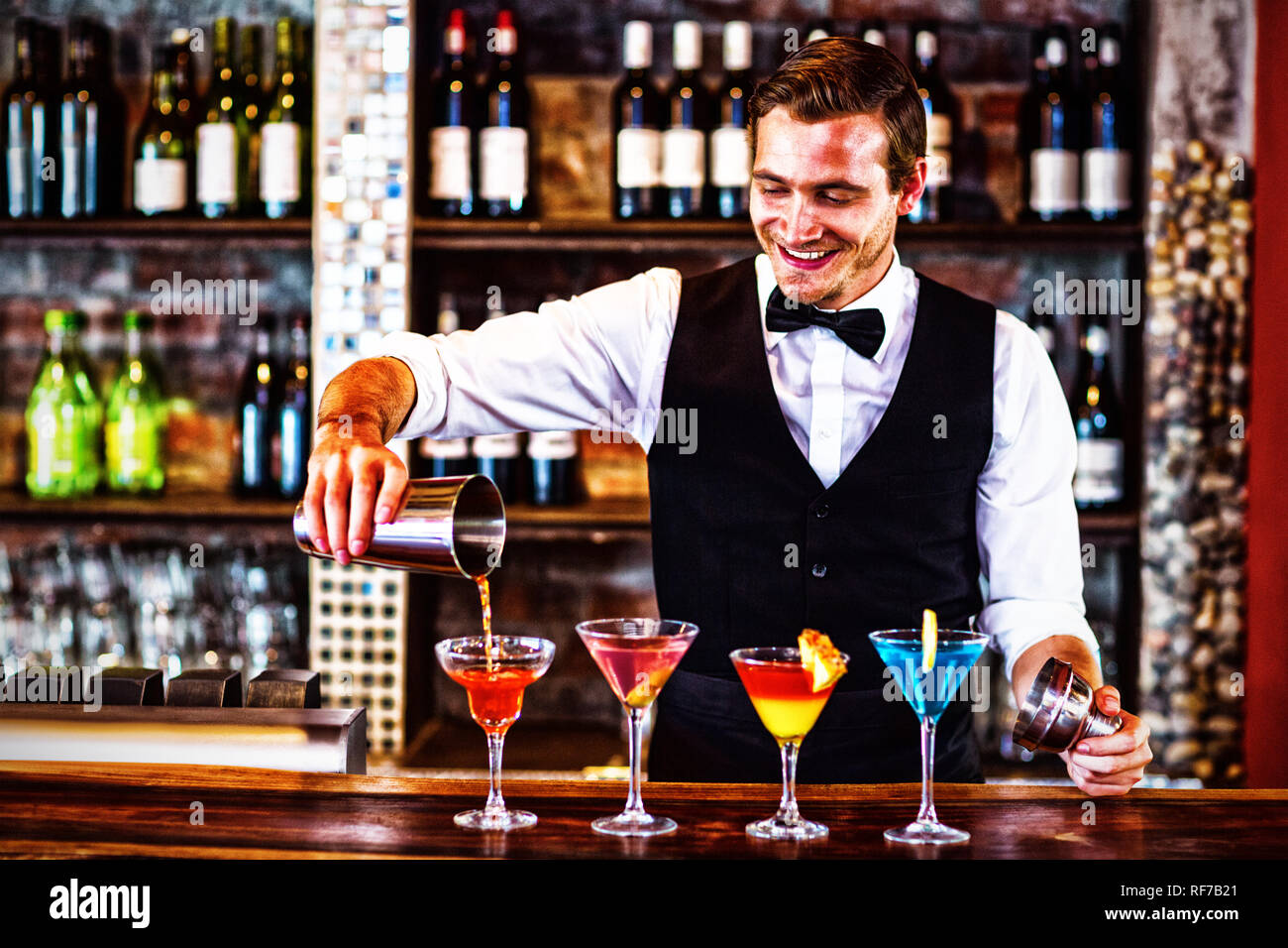 Barkeeper Gießen einen orangenen Martini trinken im Glas Stockfoto